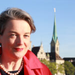 Im Vordergrund ist die Autorin Barbara Hutzl-Ronge zu sehen, im Hintergrund die Kirche Fraumünster und das Stadthaus in Zürich.
