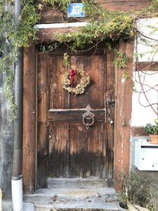 Holztür eines Bauernhauses, mit altem Schloss, geschmückt mir einem Kranz. Viele Bauern und Handwerker in den Dörfern rund um Zürich schlossen sich der neu entstehenden Täuferbewegung an.